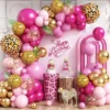 Prezentare eleganta pentru un set arcada baloane Safari Pink asimetric, cu baloane fucsia, aurii si imprimeu leopard, montat langa tort.