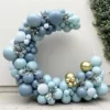 Prezentare eleganta pentru un set arcada baloane bleu si auriu, montat asimetric pe un suport rotund pentru botez sau aniversare.