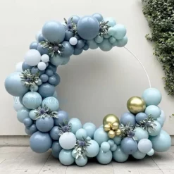 Prezentare eleganta pentru un set arcada baloane bleu si auriu, montat asimetric pe un suport rotund pentru botez sau aniversare.