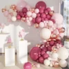 Prezentare eleganta pentru un set arcada baloane aniversare Rose Gold si Burgundy, montat asimetric intr-un decor rafinat cu baloane ivory si roz pal.