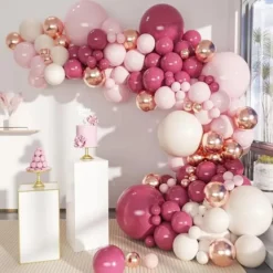 Prezentare eleganta pentru un set arcada baloane aniversare Rose Gold si Burgundy, montat asimetric intr-un decor rafinat cu baloane ivory si roz pal.
