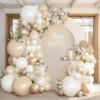 Prezentare eleganta pentru un set arcada baloane aniversare Boho Cream & Gold, montat asimetric cu baloane ivory, albe, champagne gold si transparente Bobo.