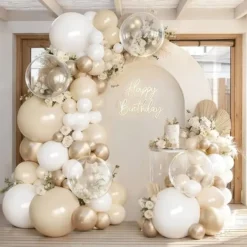 Prezentare eleganta pentru un set arcada baloane aniversare Boho Cream & Gold, montat asimetric cu baloane ivory, albe, champagne gold si transparente Bobo.