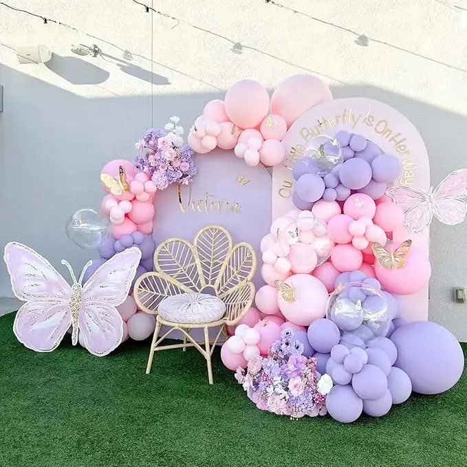 Prezentare eleganta pentru un set arcada baloane aniversare fetite in nuante de roz, lila si mov, decorata cu fluturi 3D aurii.