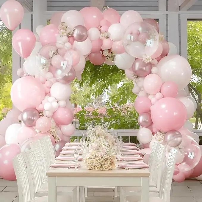 Prezentare eleganta pentru un set arcada baloane aniversare Soft Pink & Rose Gold, montat asimetric cu baloane roz pastel, blush, albe, rose gold metalizat si transparente Bobo.