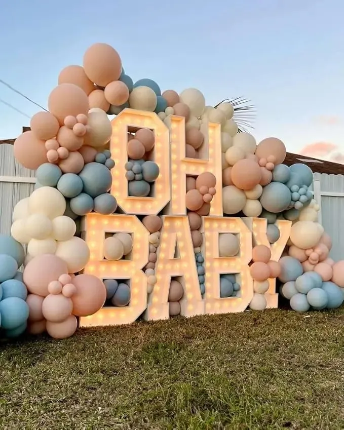 Prezentare eleganta pentru un set arcada baloane pastel mix, montat asimetric in culori de roz, bleu si ivory pentru un baby shower sau gender reveal.