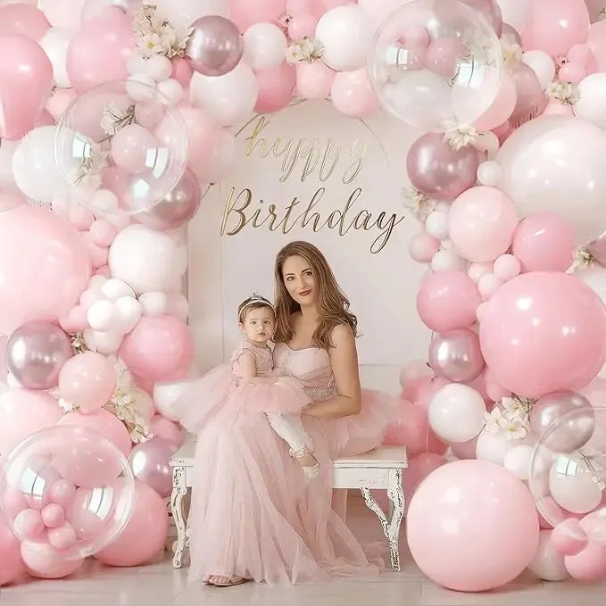 Prezentare eleganta pentru un set arcada baloane aniversare Soft Pink & Rose Gold, montat asimetric cu baloane roz pastel, blush, albe, rose gold metalizat si transparente Bobo.