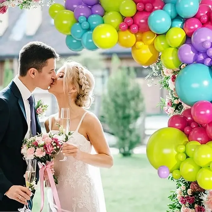 Prezentare eleganta pentru un set arcada baloane aniversare Tropical Neon multicolor, montat asimetric in culori de galben, verde neon, turcoaz, fucsia si mov.