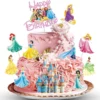 Tort roz decorat cu un set de topper tort printese si un castel regal.