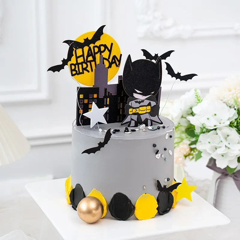 Set de decoratiuni pentru tort cu tema Batman, incluzand silueta neagra a orasului, luna galbena cu Happy Birthday si personajul decorativ.