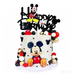 Topper pentru tort cu sclipici negru reprezentand mesajul Happy Birthday si personajul Mickey Mouse pozitionat in partea de sus a unui tort.